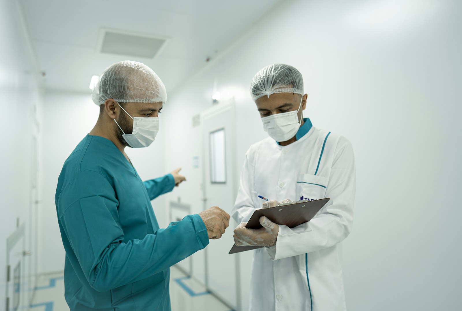 Two healthcare workers talking through notes on a clipboard